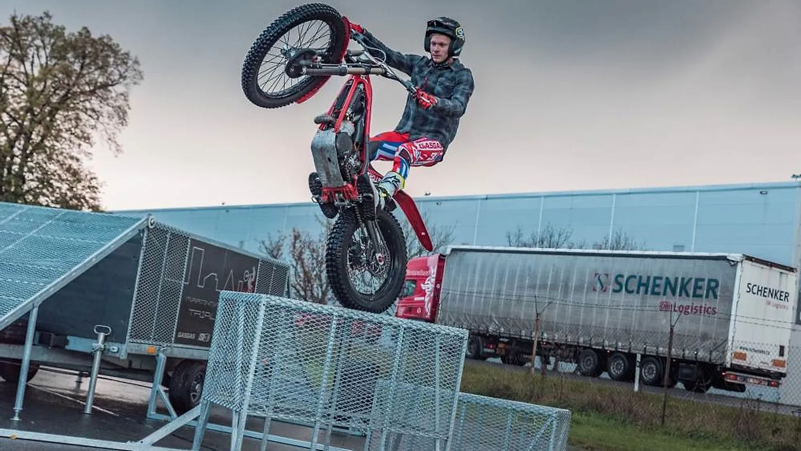 Trialový jezdec Martin Matějíček přeskakuje na motorce kovové zábrany
