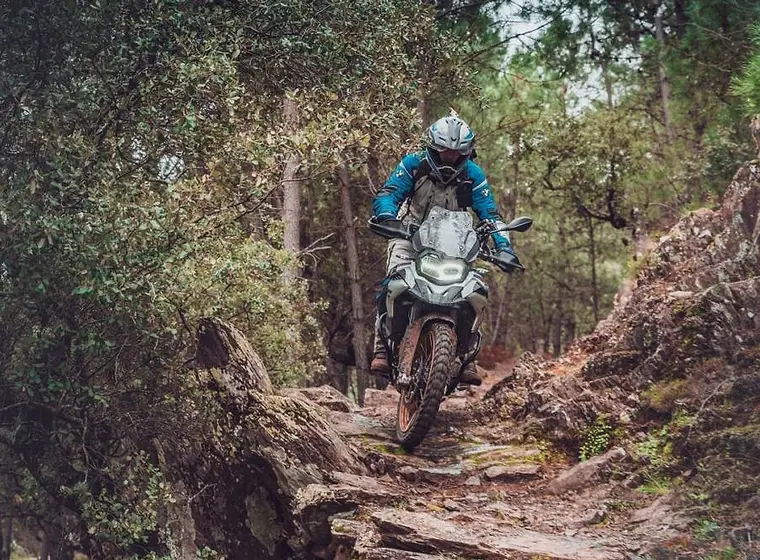 Jezdec na BMW GS na kamenité lesní stezce