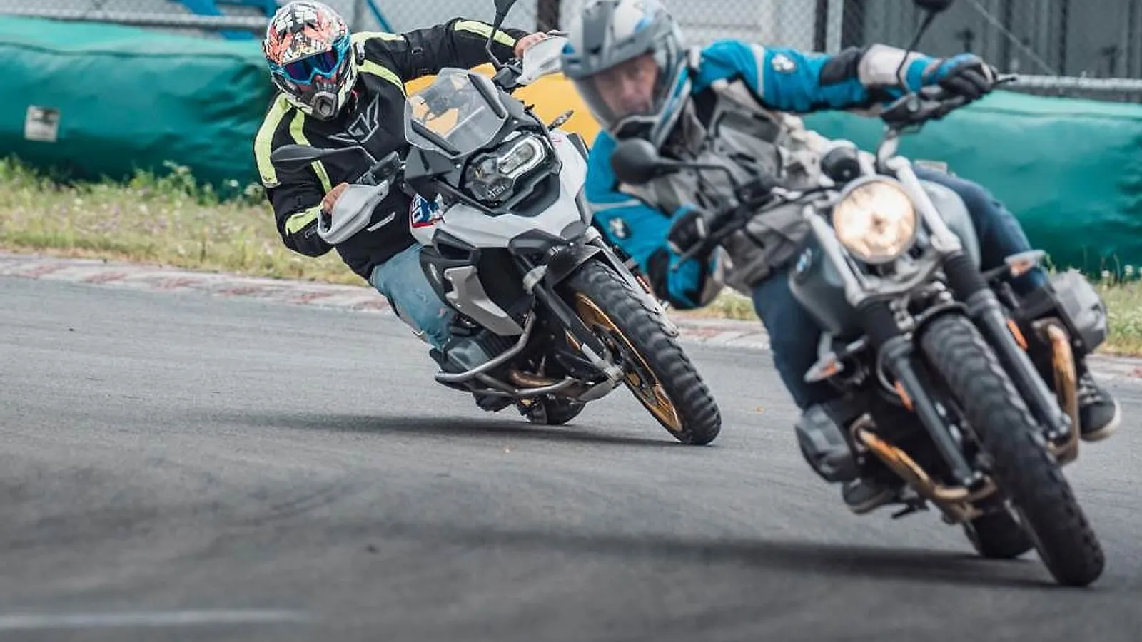 Dva jezdci v náklonu v zatáčce závodního okruhu ve Vysokém Mýtě, vpředu BMW R 1250 GS