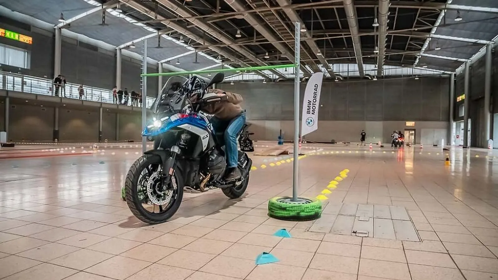 Jezdec na BMW GS projíždí slalom mezi kužely v hale brněnského výstaviště