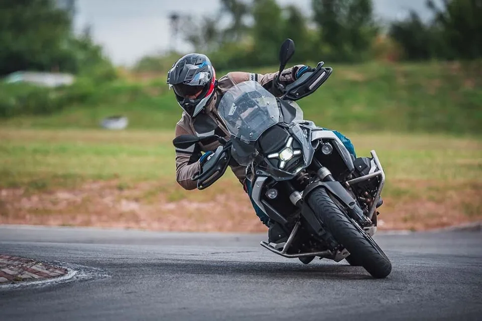 Jezdec na BMW GS v hlubokém náklonu v asfaltové zatáčce
