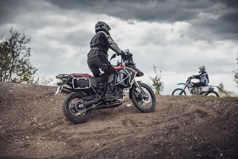 Jezdec na endurové motorce v terénu pod zataženou zimní oblohou