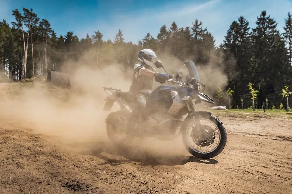 Jezdec dostává BMW GS do smyku a zvedá oblak prachu na terénní trati