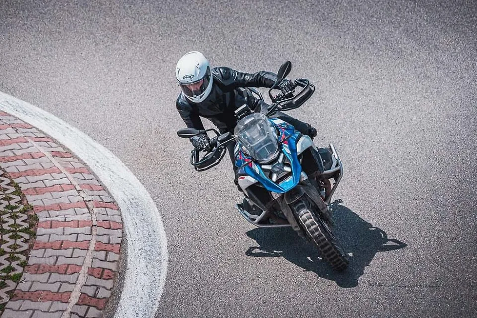 Pohled shora na jezdce na BMW GS v zatáčce závodního okruhu